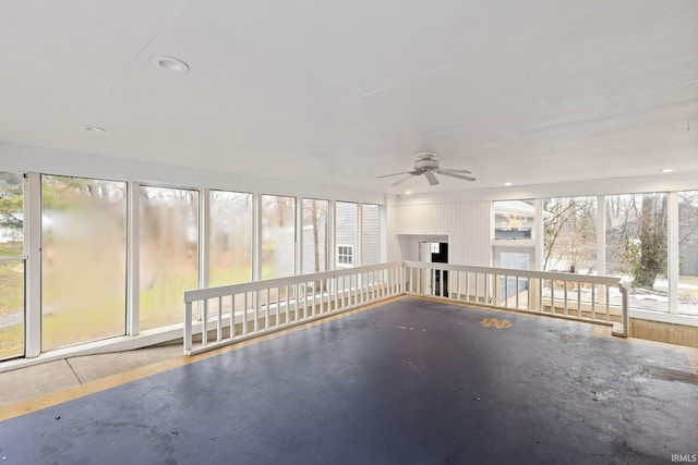 unfurnished sunroom with ceiling fan