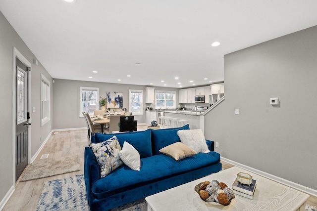 living room with a wealth of natural light and light hardwood / wood-style floors