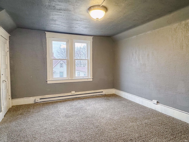 empty room featuring a baseboard radiator, carpet flooring, vaulted ceiling, and a textured ceiling