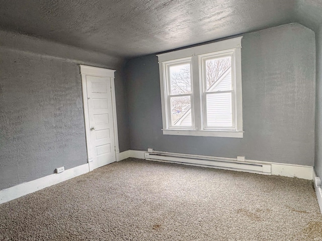 spare room featuring carpet, a textured ceiling, and baseboard heating