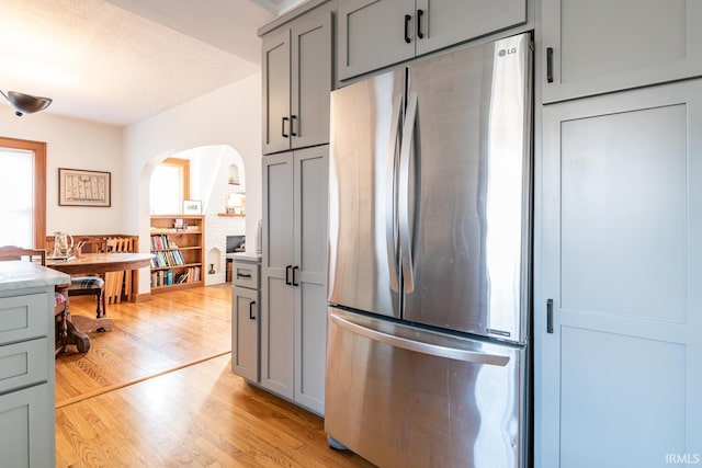 kitchen featuring light hardwood / wood-style flooring, stainless steel fridge, and gray cabinets