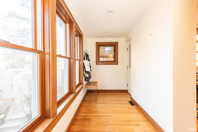 corridor with light hardwood / wood-style floors