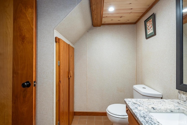 bathroom with vanity, vaulted ceiling, tile patterned floors, and toilet