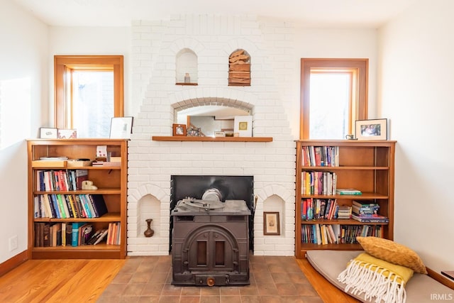 living area featuring wood-type flooring and a wood stove