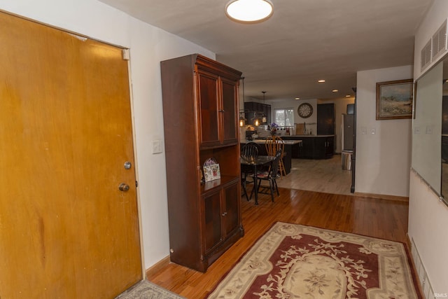 hallway with hardwood / wood-style flooring