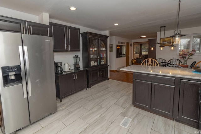 kitchen featuring hanging light fixtures, dark brown cabinets, and stainless steel fridge with ice dispenser