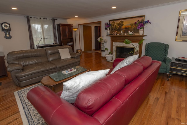 living room featuring ornamental molding, a high end fireplace, and light hardwood / wood-style flooring