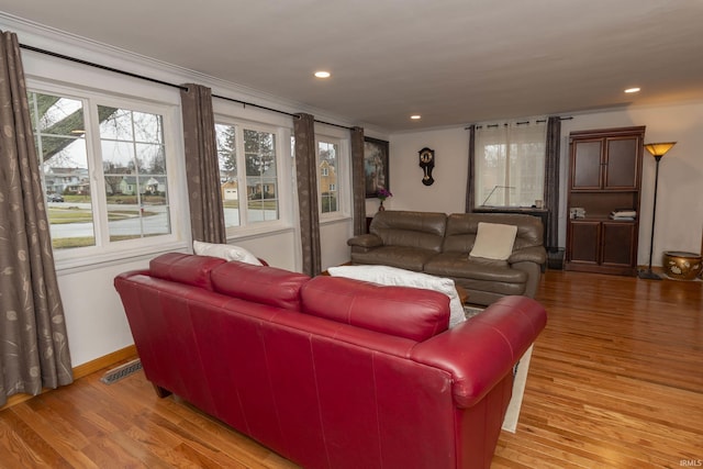 living room featuring crown molding and light hardwood / wood-style floors