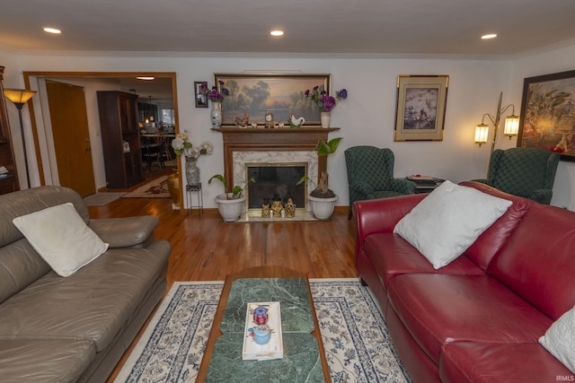 living room featuring a premium fireplace, crown molding, and hardwood / wood-style floors