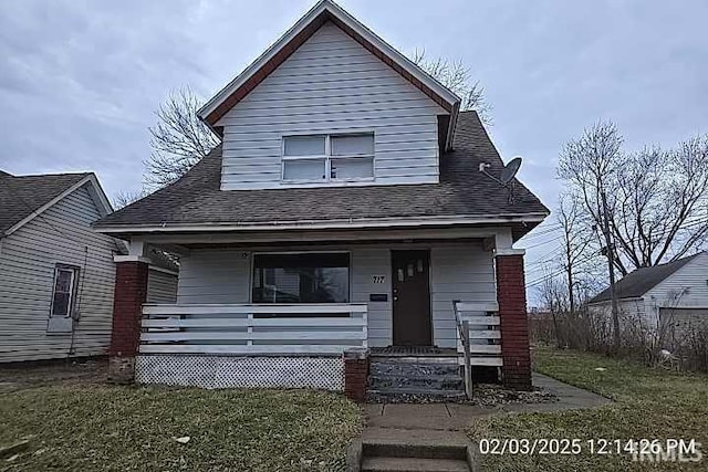 bungalow with a porch and a front lawn