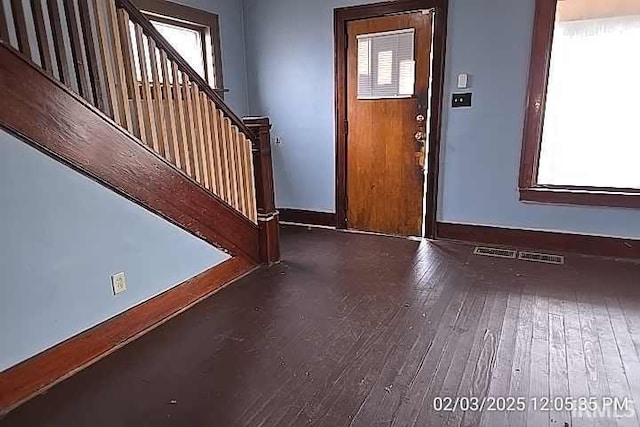 foyer entrance with a wealth of natural light and dark hardwood / wood-style flooring