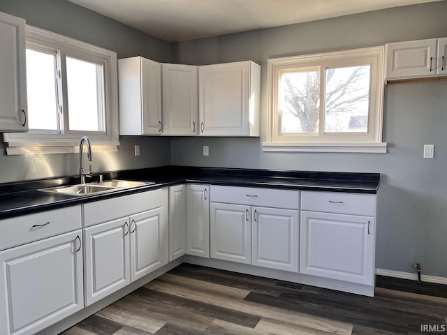 kitchen featuring dark hardwood / wood-style flooring, sink, and white cabinets