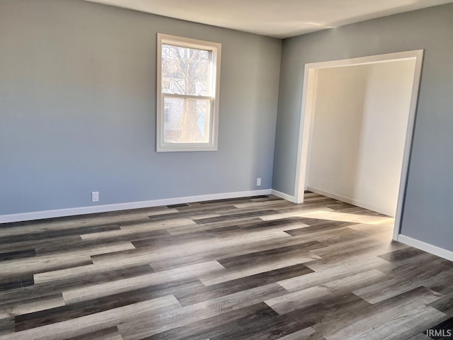 unfurnished room with dark wood-type flooring