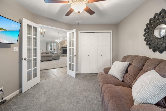 living room with ceiling fan with notable chandelier, french doors, and carpet flooring