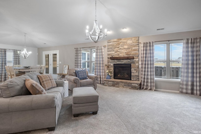 living room featuring carpet, a wealth of natural light, a notable chandelier, and a fireplace