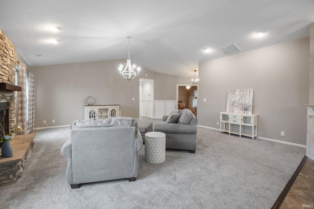 carpeted living room with a stone fireplace, a chandelier, and vaulted ceiling