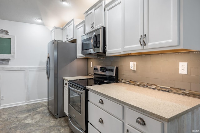 kitchen with stainless steel appliances, white cabinetry, and tasteful backsplash