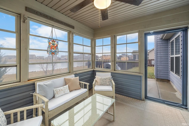 sunroom with a water view and ceiling fan