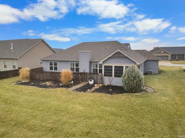 rear view of house with a yard and central air condition unit