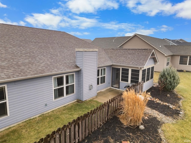 rear view of house with a lawn and a sunroom