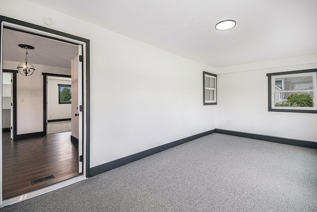 unfurnished room with an inviting chandelier