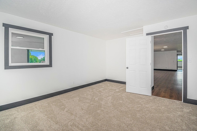 carpeted spare room featuring plenty of natural light and a textured ceiling