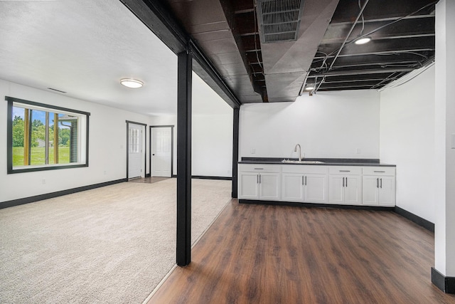 basement featuring dark carpet and wet bar