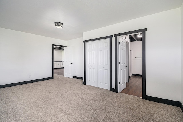 unfurnished bedroom with dark colored carpet and a closet