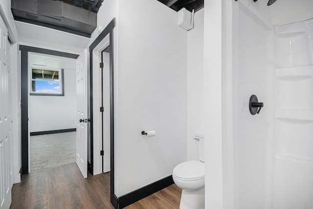 bathroom featuring hardwood / wood-style floors, a shower, and toilet