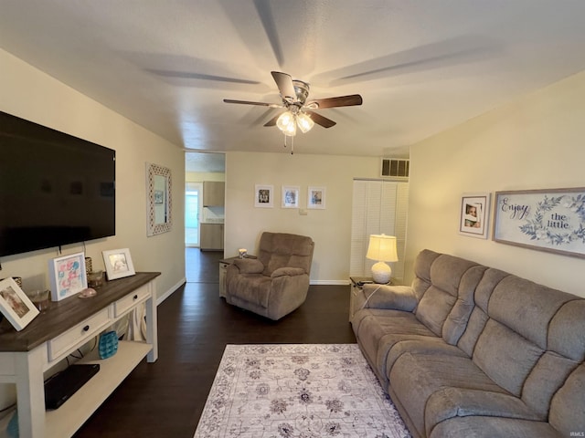 living room featuring ceiling fan and dark hardwood / wood-style flooring