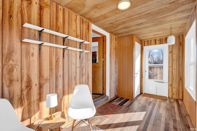 interior space with hardwood / wood-style flooring, wood walls, and wooden ceiling