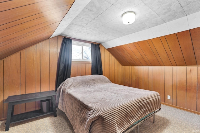 bedroom featuring vaulted ceiling, light carpet, and wood walls