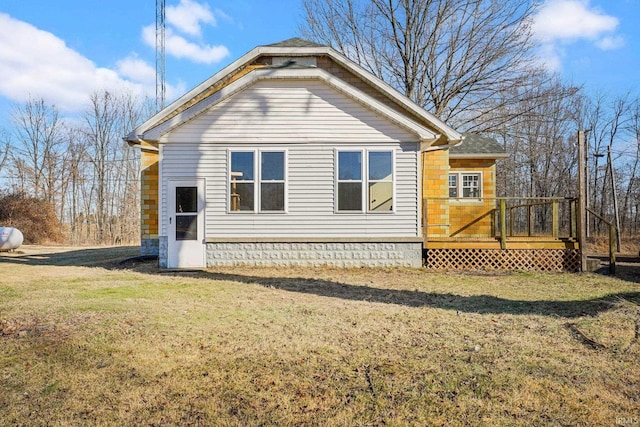 view of property exterior featuring a wooden deck and a lawn