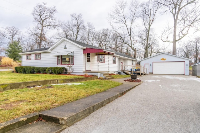 view of front of home with a garage, an outdoor structure, and a front lawn