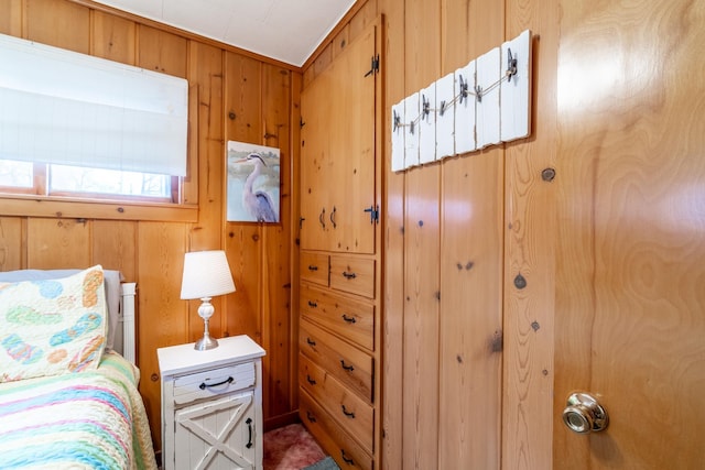 bedroom featuring wood walls