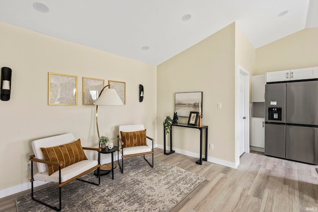 sitting room featuring vaulted ceiling and light hardwood / wood-style floors