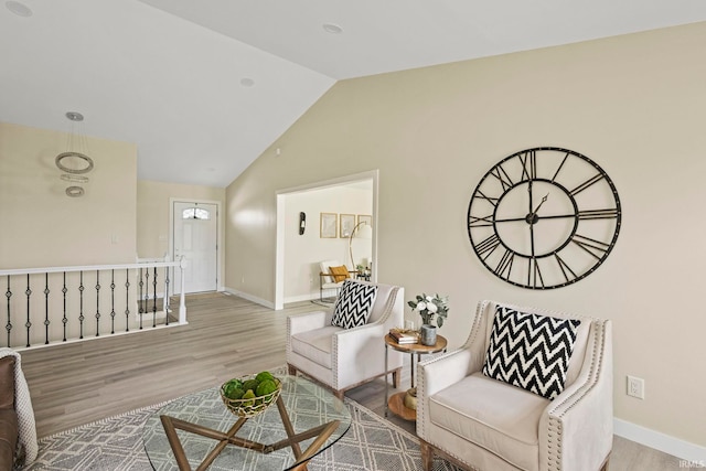 living area featuring lofted ceiling and light hardwood / wood-style flooring