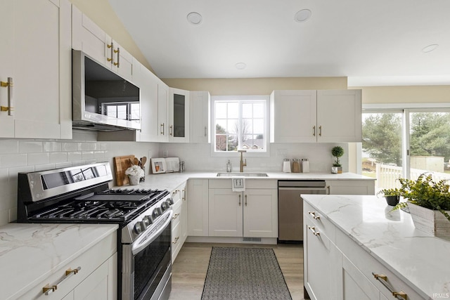 kitchen with appliances with stainless steel finishes, sink, and white cabinets