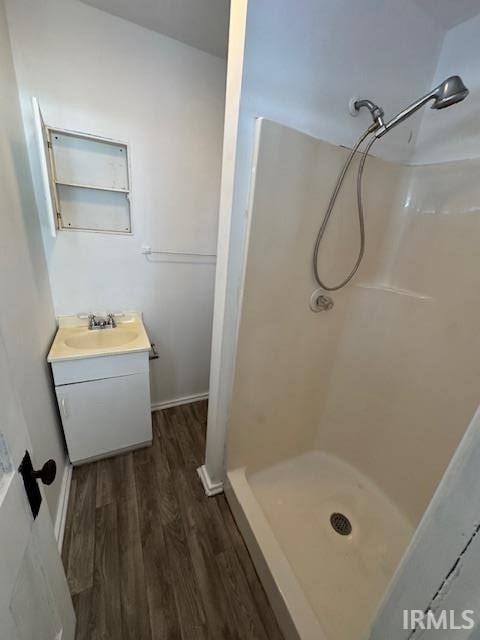 bathroom with wood-type flooring, vanity, and walk in shower