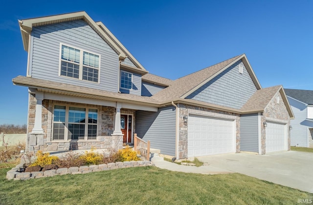 craftsman house with a garage, covered porch, and a front yard