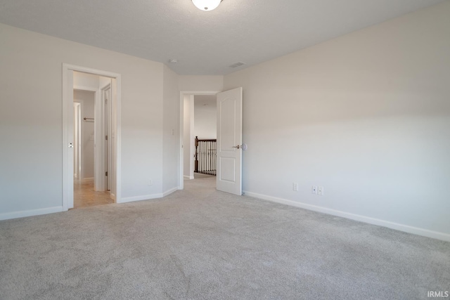 unfurnished bedroom featuring light carpet and a textured ceiling