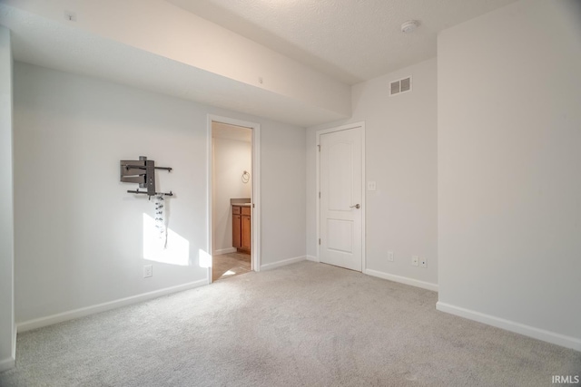 unfurnished room featuring light colored carpet and a textured ceiling