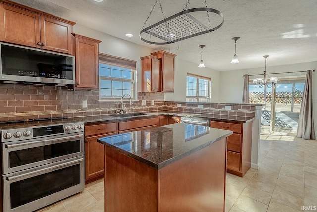 kitchen with a kitchen island, decorative light fixtures, sink, decorative backsplash, and stainless steel appliances