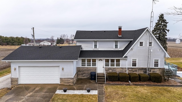 rear view of property with a garage and a lawn