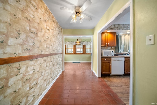 hall featuring dark tile patterned floors and sink