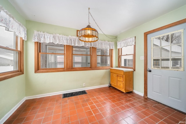 unfurnished dining area featuring tile patterned floors