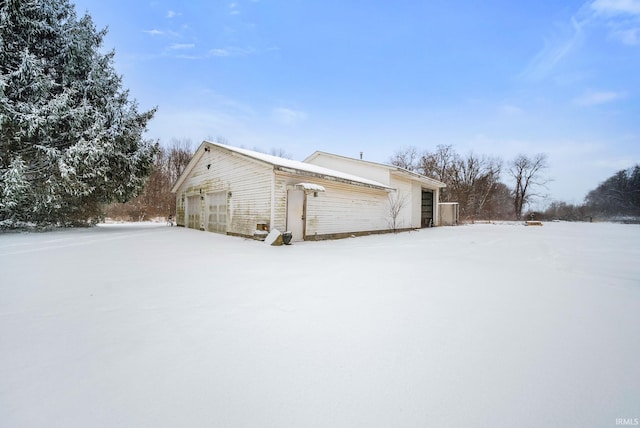 snow covered property with a garage