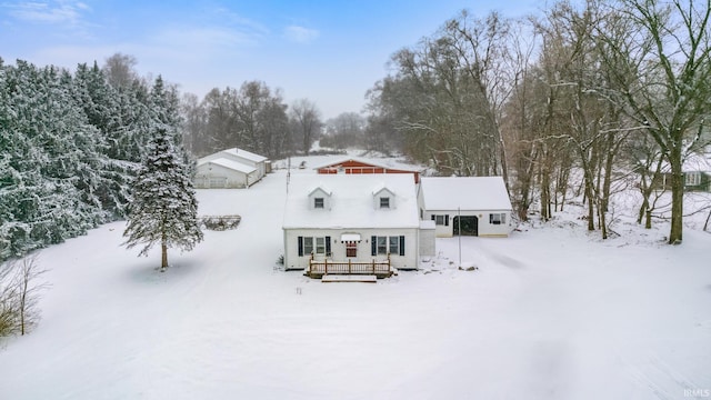 snow covered house with a wooden deck