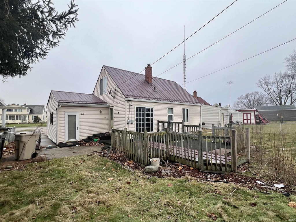 back of house with a wooden deck and a yard