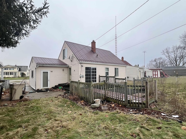 back of house with a wooden deck and a lawn